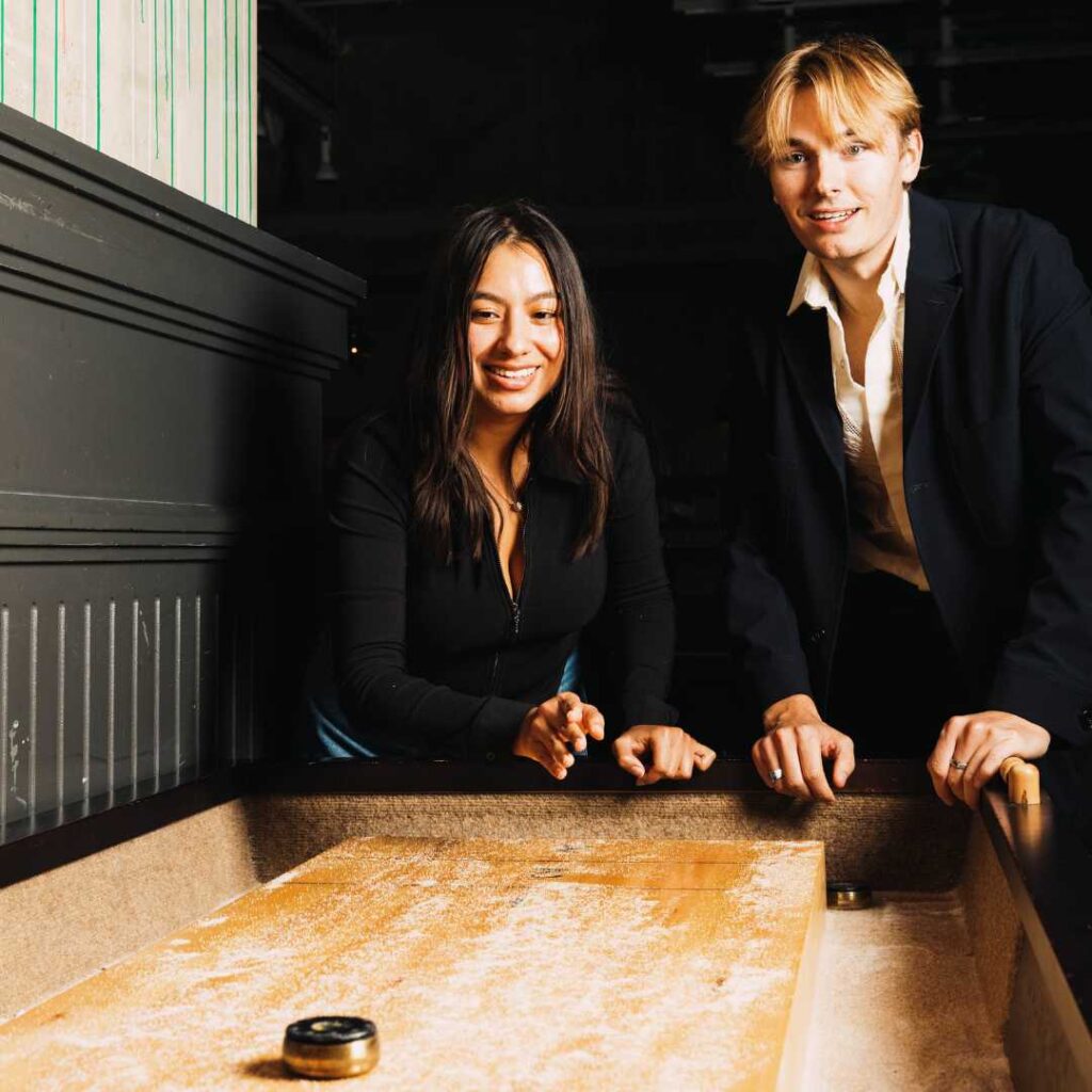 two individuals enjoying a game of shuffleboard together