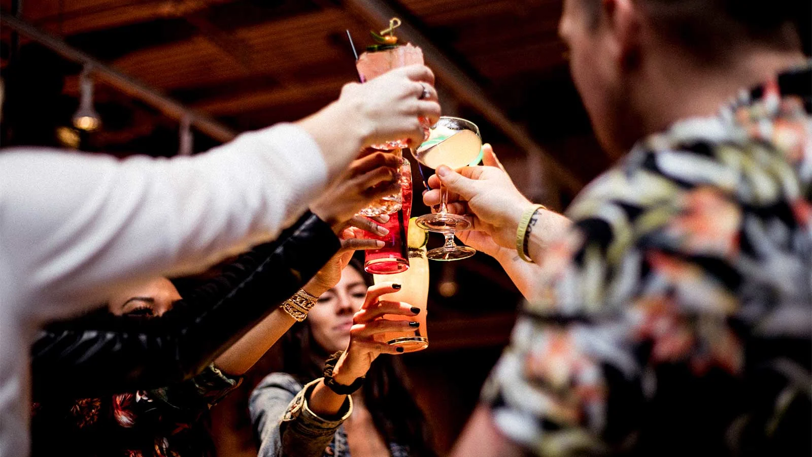 A group of coworkers raising a toast with craft cocktails while celebrating corporate holiday party ideas in Chicago at AceBounce.
